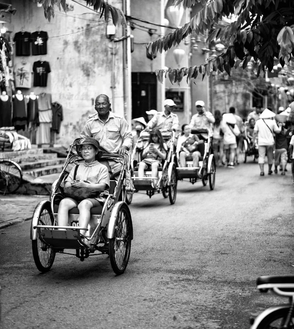 a group of people riding motorcycles down a street, a black and white photo, by Daniel Gelon, carriage, tourism photography, son, cinematic. by leng jun