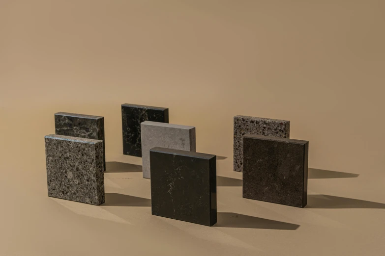 a group of lighters sitting on top of a table, inspired by David Chipperfield, bauhaus, granite, brown resin, panel of black, all marble