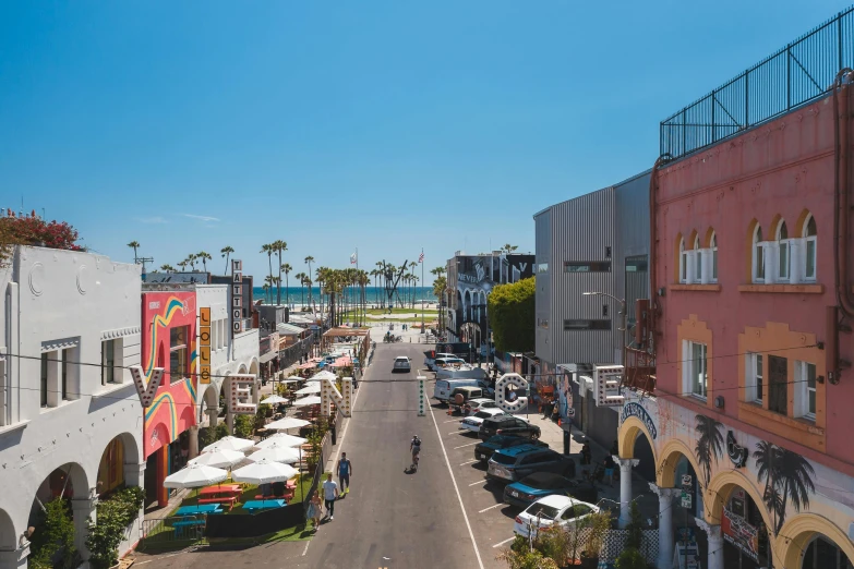 a city street filled with lots of parked cars, by Ryan Pancoast, pexels contest winner, renaissance, summer street near a beach, it's californication, storefronts, frank gehry