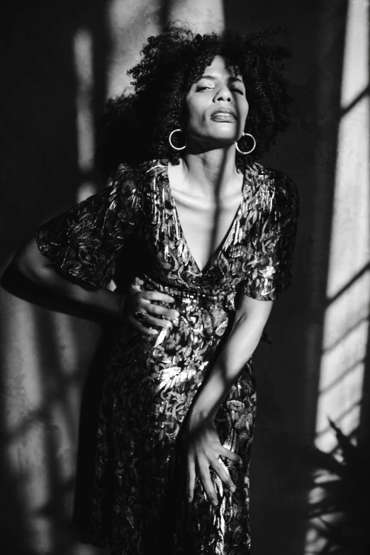 a black and white photo of a woman in a dress, inspired by Gordon Parks, pexels contest winner, tessa thompson inspired, glittering light, taken in the late 1980s, studio medium format photograph