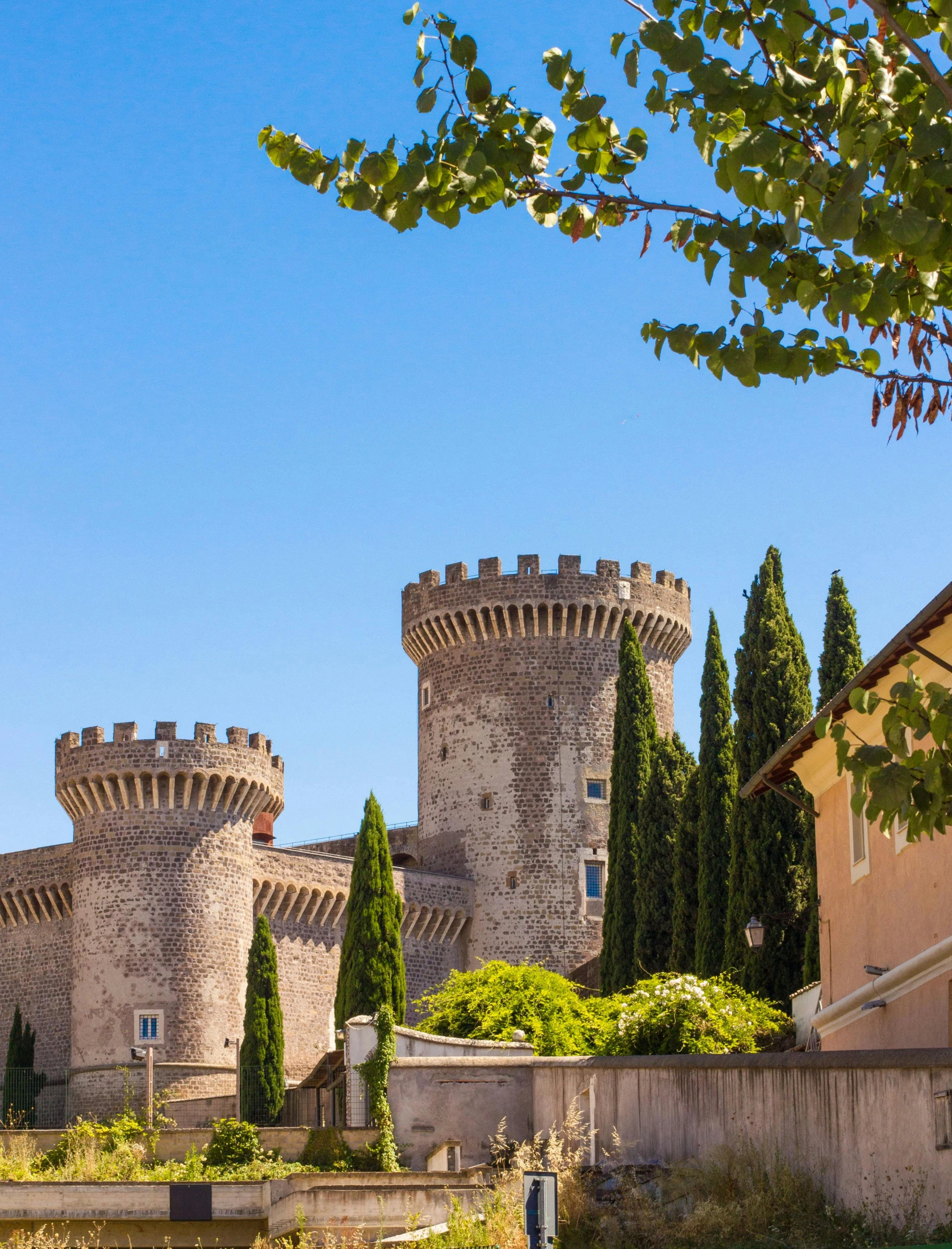 a large castle sitting on top of a lush green field, inspired by Serafino De Tivoli, city walls, cypresses, award - winning, baroque winding cobbled streets
