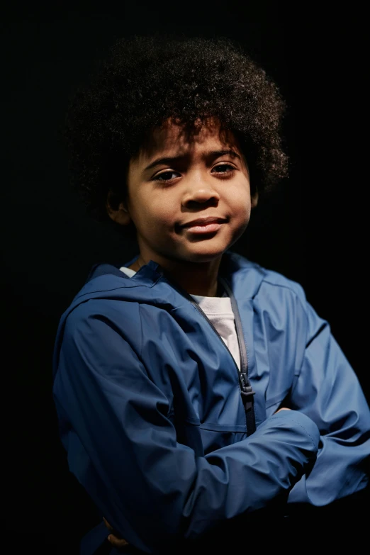 a boy in a blue jacket posing for a picture, with a black background, thumbnail, with afro, promotional image