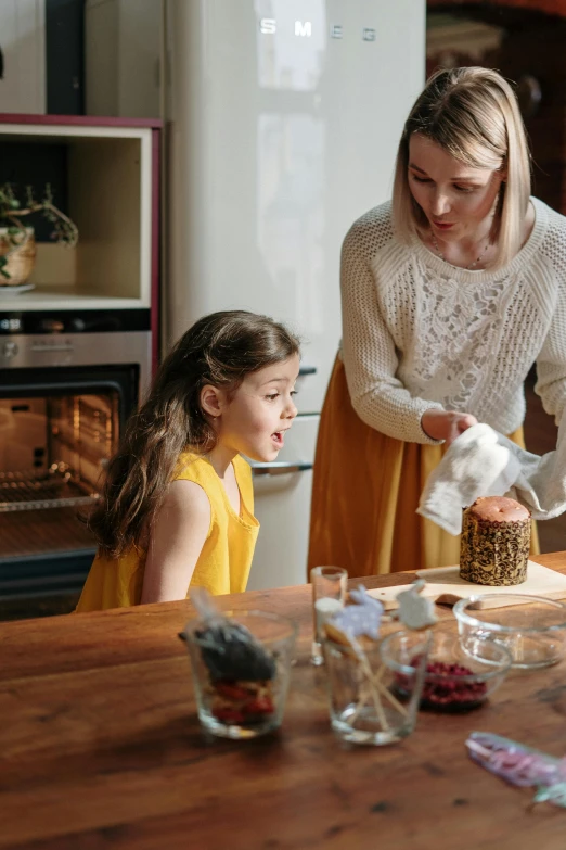 a woman and two young girls in a kitchen, by Elizabeth Durack, pexels contest winner, during autumn, cake, transparent background, manuka