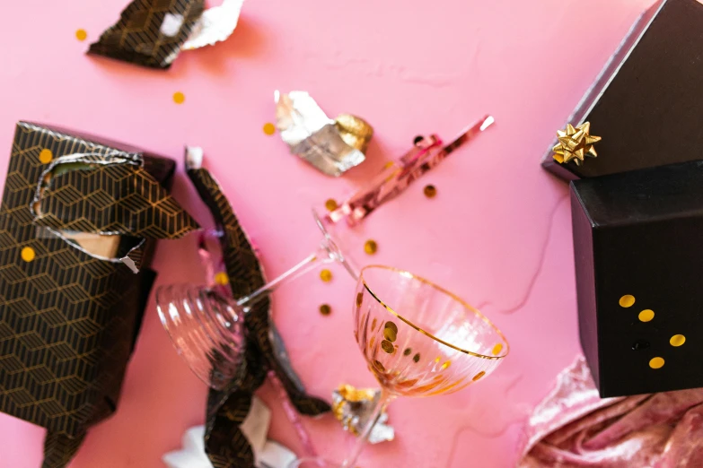 a black gift box sitting on top of a pink table, a still life, by Julia Pishtar, pexels contest winner, happening, shattered glass, drinking champagne, background image