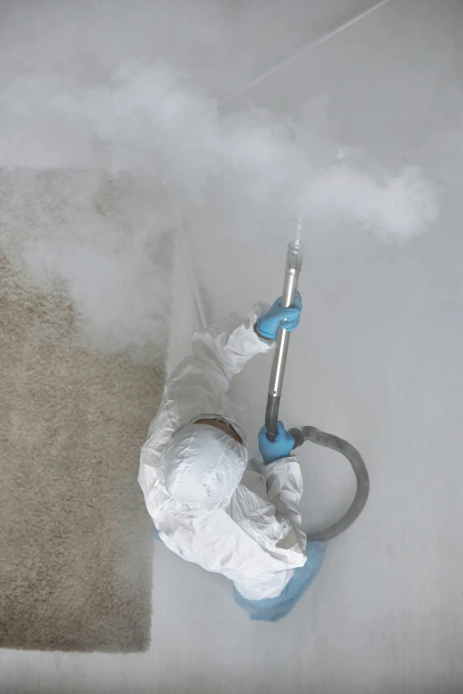 a person using a vacuum to clean a carpet, an airbrush painting, by Ben Zoeller, process art, white smoke, wearing nanotech honeycomb robe, white concrete floor, blue