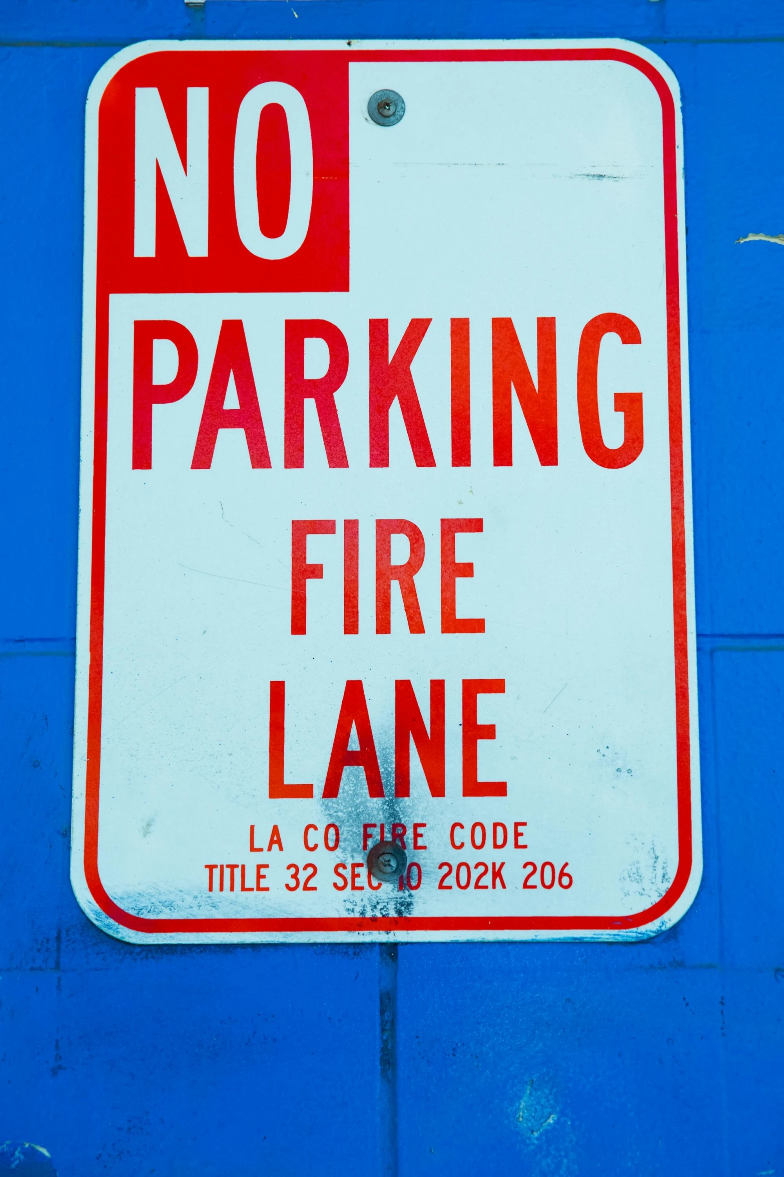 a no parking fire lane sign on a blue wall, by Bernie D’Andrea, coding, 2 0 0 0 s