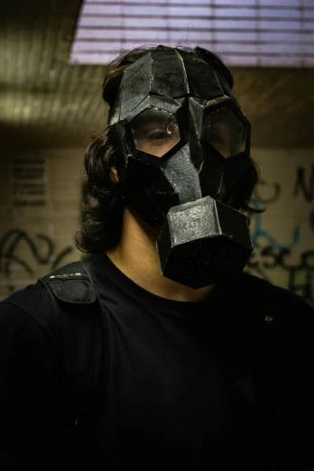 a man wearing a gas mask in a dark room, an album cover, reddit, black shirt underneath armor, cosplay photo, profile image, family photo