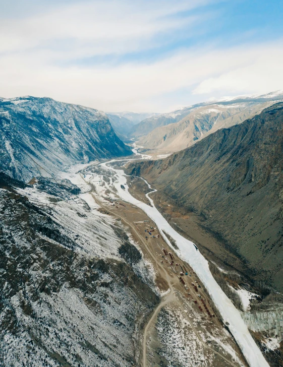 an aerial view of a valley in the mountains, by Matthias Stom, pexels contest winner, hurufiyya, inuit heritage, massive river, mining outpost, conde nast traveler photo