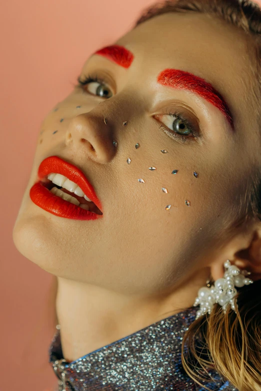 a woman with red lipstick and glitter on her face, an album cover, inspired by Elsa Bleda, trending on pexels, pop art, red jewelry, white eyebrows, coral lipstick, pierced