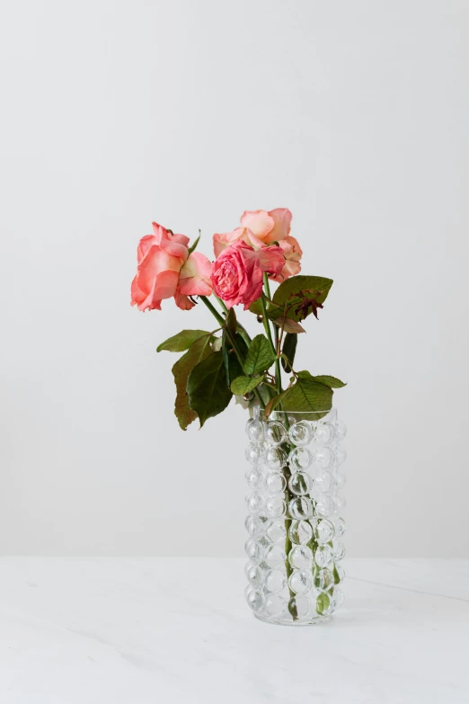 a vase filled with pink roses sitting on a table, inspired by Aimé Barraud, crystal cubism, hand carved, close together, tufted softly, small