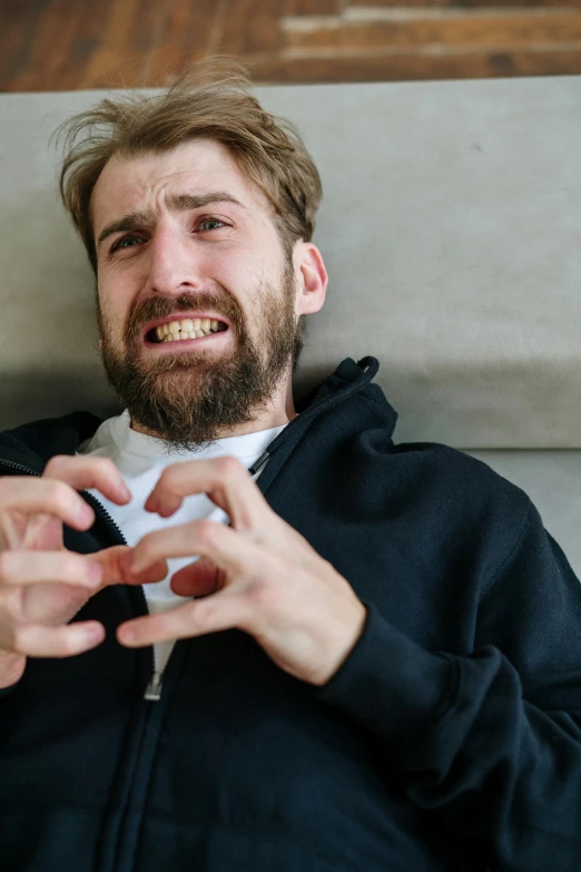 a man sitting on a couch playing a video game, by Sebastian Spreng, trending on pexels, renaissance, heart shaped face, heavy gesture style closeup, asmongold, cracks