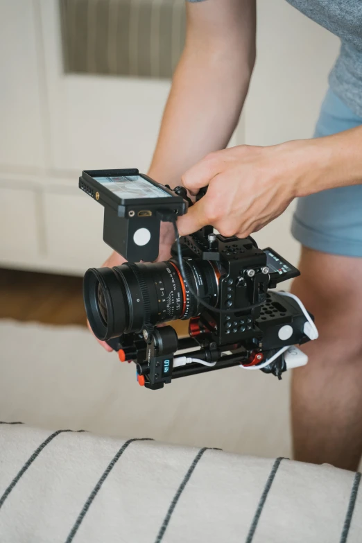 a close up of a person holding a camera, movie setup, canon on chest, alexa mini, home video footage