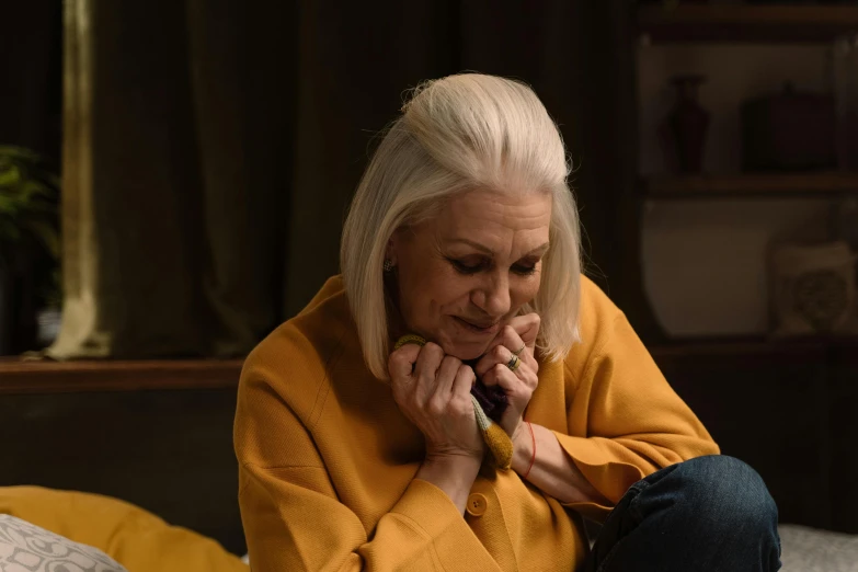 a woman sitting on a bed talking on a cell phone, inspired by Joanna Carrington, trending on pexels, photorealism, relaxed dwarf with white hair, with yellow cloths, coughing, tv show still