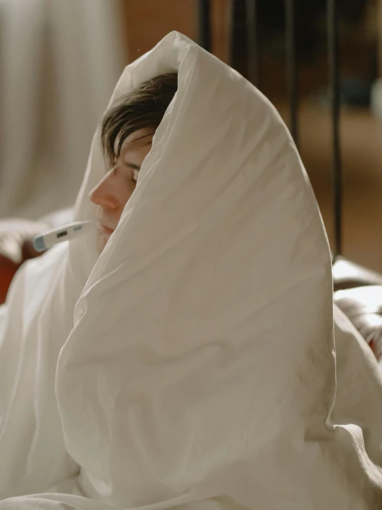 a woman laying in bed with a cigarette in her mouth, pexels contest winner, happening, cloak covering face, sick with a cold, boy with neutral face, wearing white cloths