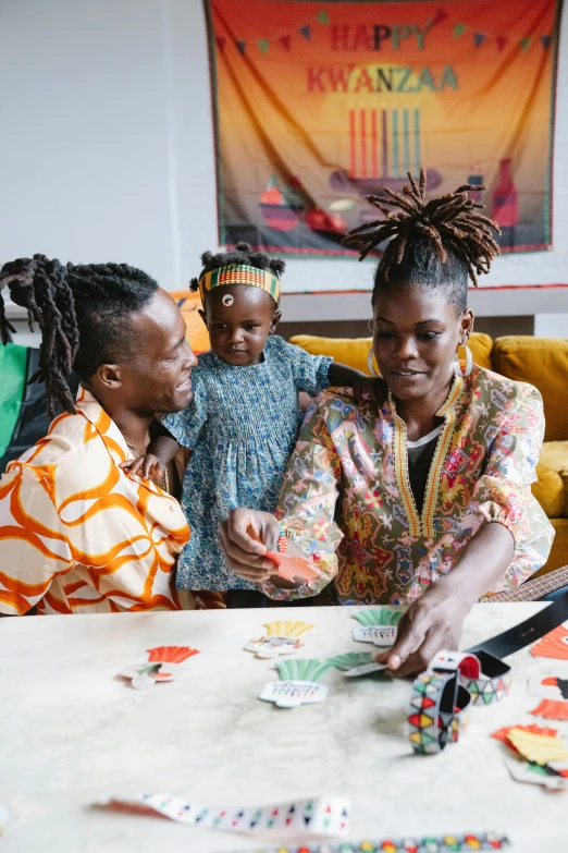 a group of people sitting around a table, by Ingrida Kadaka, pexels contest winner, black arts movement, portrait of family of three, cardistry, lgbtq, at home