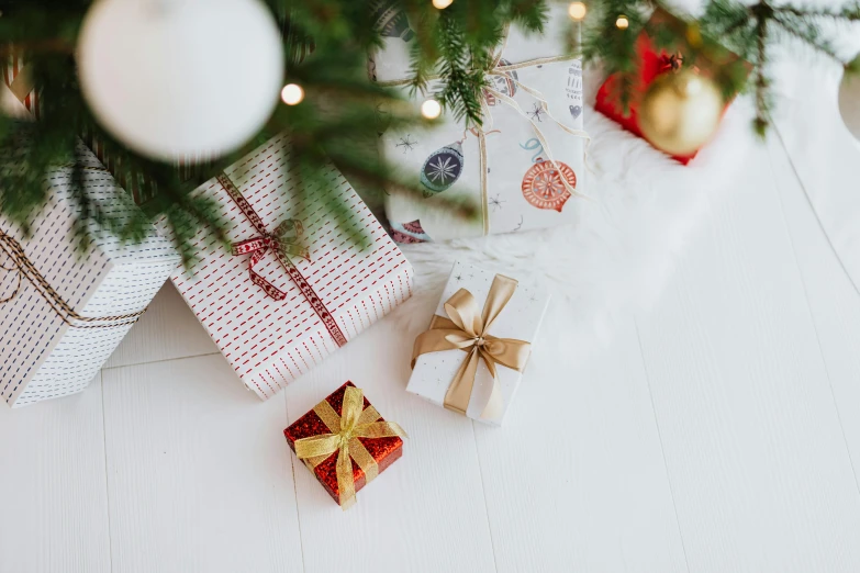 a close up of presents under a christmas tree, by Julia Pishtar, pexels, on a white table, gif, ilustration, group photo