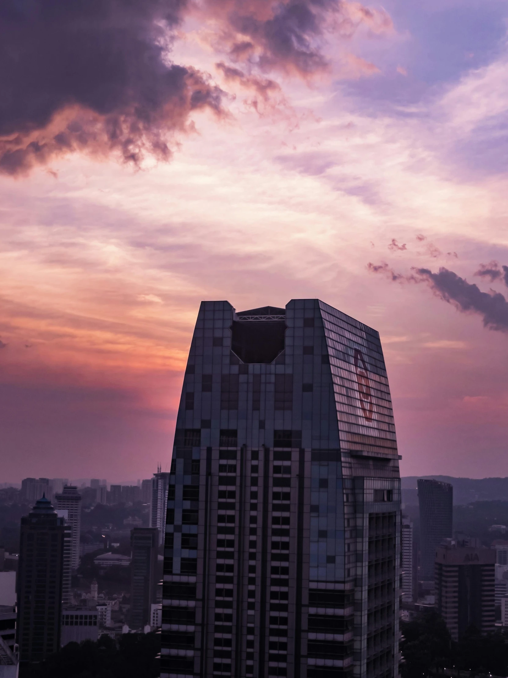 a very tall building sitting in the middle of a city, by Patrick Ching, pexels contest winner, pink storm clouds, set on singaporean aesthetic, sitting on a skyscraper rooftop, instagram post