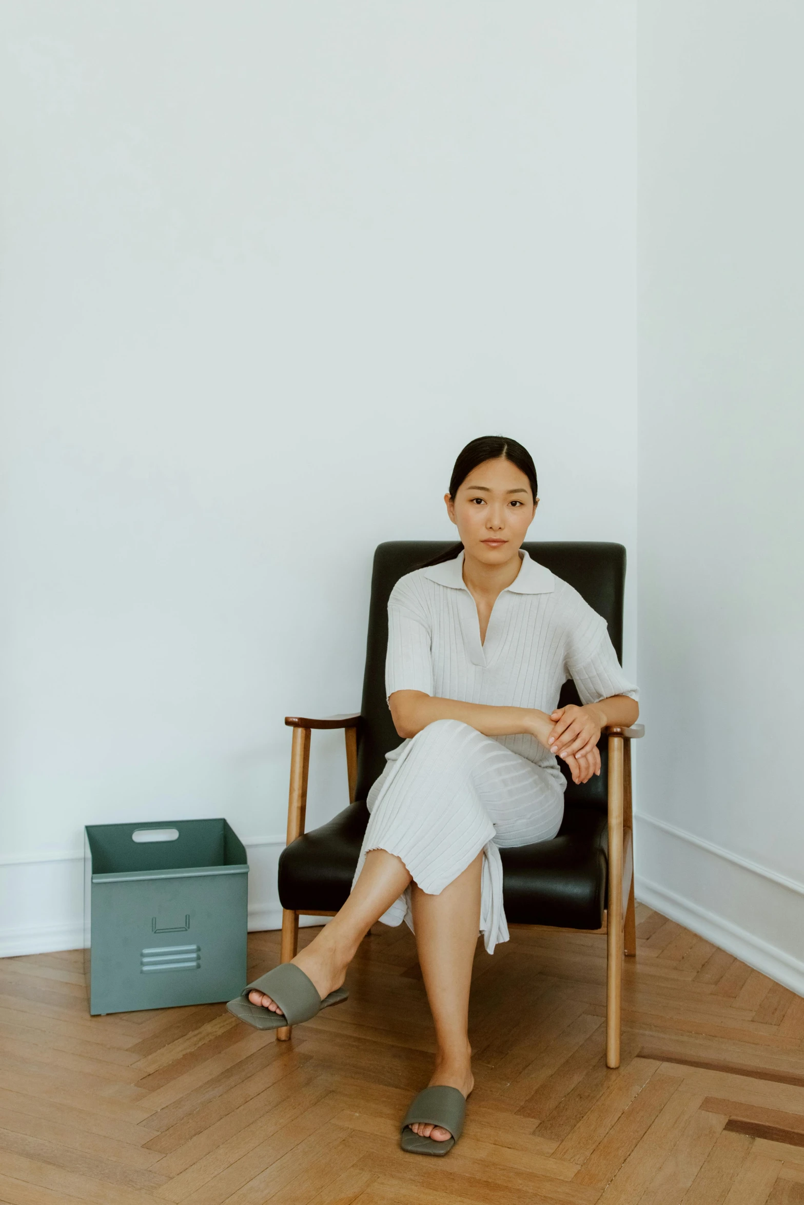 a woman sitting in a chair in a room, jen yoon, office clothes, in white room, seated in royal ease