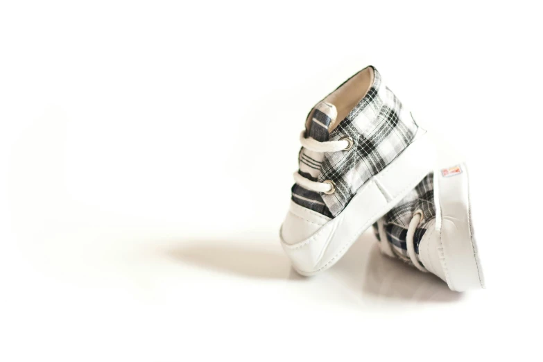 a close up of a pair of shoes on a white surface, a digital rendering, unsplash, tartan garment, little kid, birth, black white