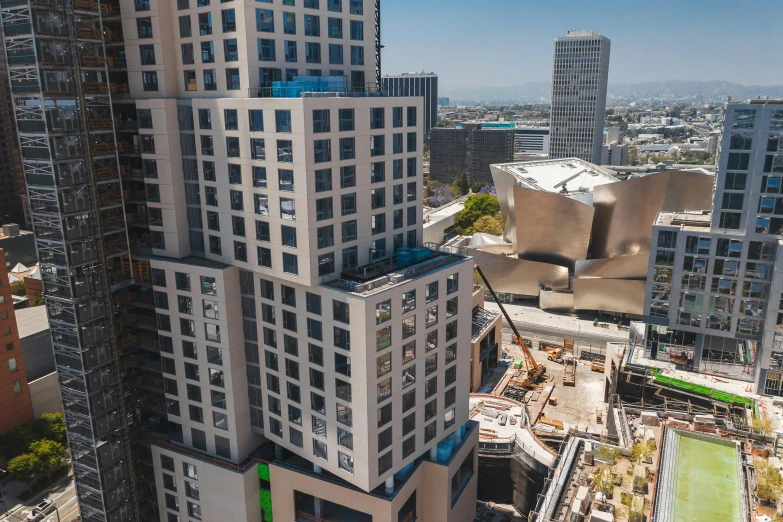 a very tall building sitting in the middle of a city, a digital rendering, inspired by Victor Enrich, unsplash, bauhaus, hollywood standard, as seen from the canopy, frank gehry, “wide shot