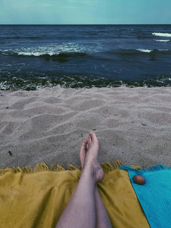 a person laying on a towel on the beach, profile image, thalassophobia, outdoor photo