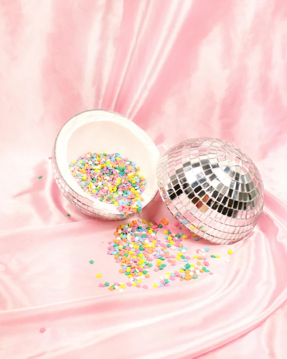 a disco ball and sprinkles on a pink cloth, by Rachel Reckitt, full product shot, metal lid, modelling, mix