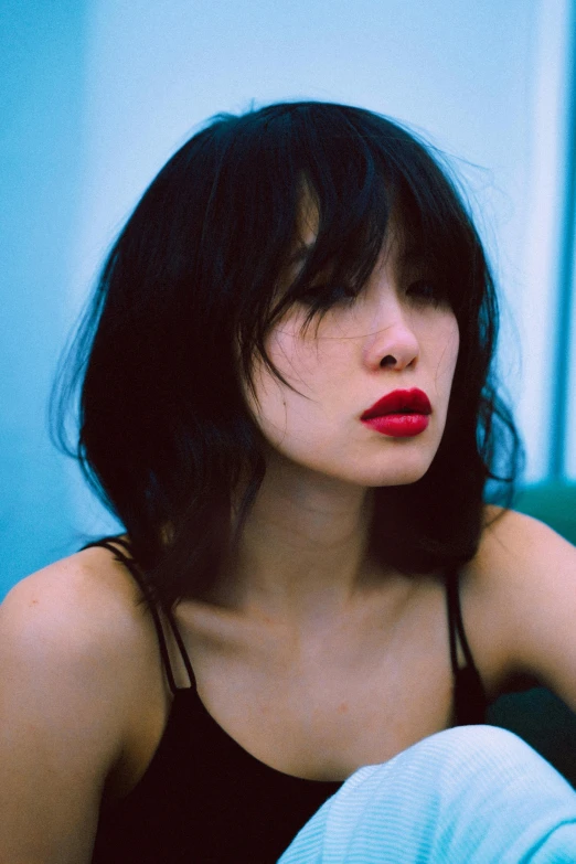 a woman with a red lipstick sitting on a couch, inspired by Itō Shinsui, unsplash, messy black bob hair, kim jung giu, curtain bangs, headshot profile picture