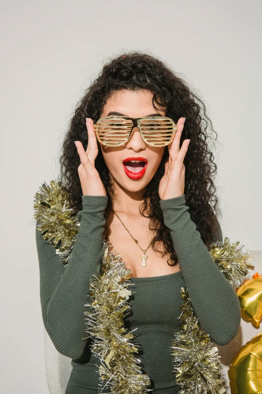 a woman in a green dress holding a gold balloon, trending on pexels, wearing 3 d glasses, wearing festive clothing, curly, wooden