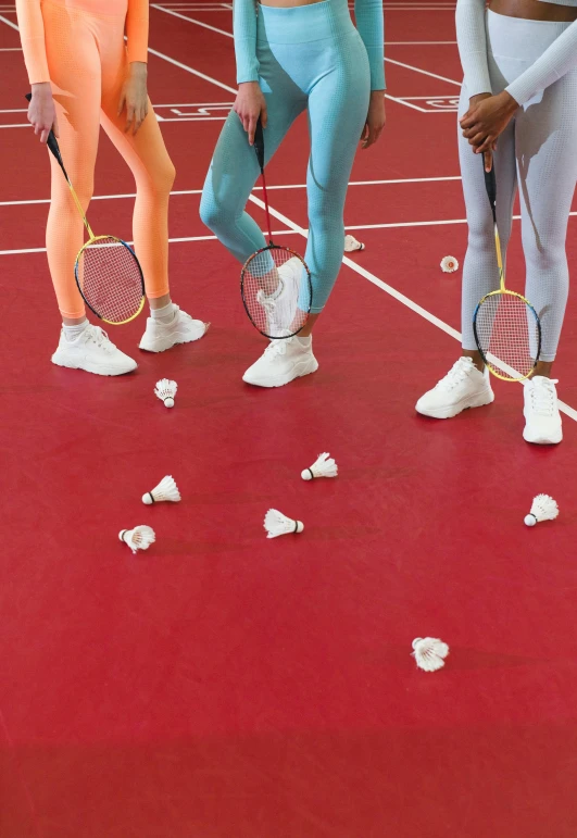 a group of women standing on top of a tennis court, by Arabella Rankin, trending on dribble, white flowers on the floor, red white and gold color scheme, badminton, close-up on legs