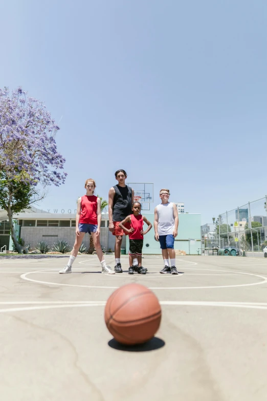 a group of people standing on top of a basketball court, by Gavin Hamilton, dribble contest winner, los angelos, family friendly, promo image, wide establishing shot