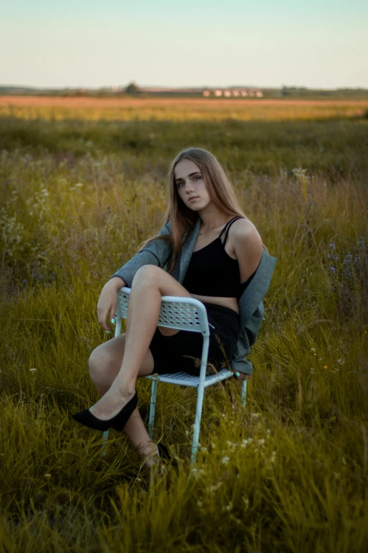 a woman sitting in a chair in a field, a portrait, by Ivan Grohar, pexels contest winner, 🤤 girl portrait, high school, late summer evening, leg shot