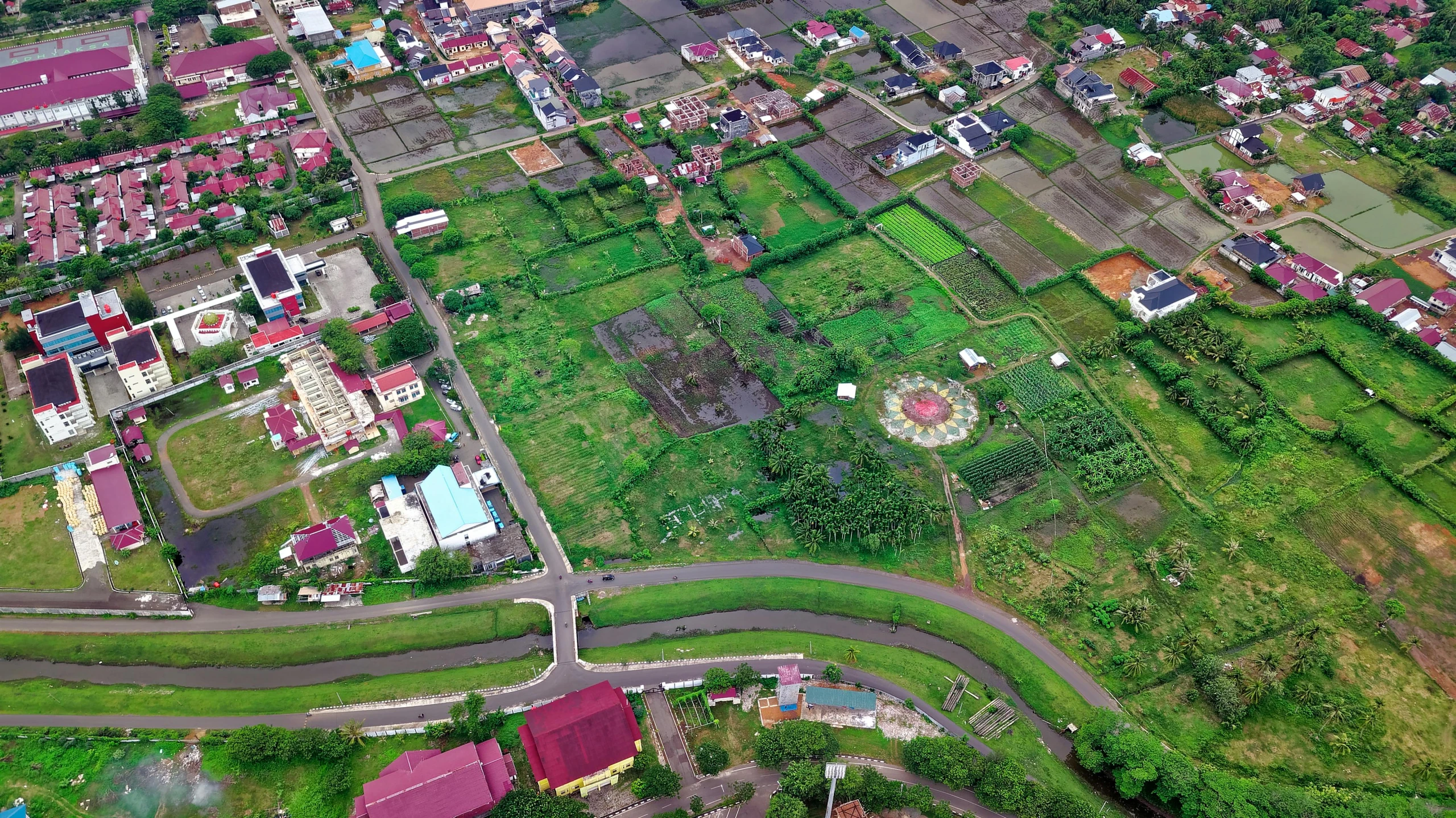 a bird's eye view of a small town, an album cover, by Basuki Abdullah, shutterstock, sumatraism, patches of green fields, biroremediation, located in hajibektash complex, thumbnail