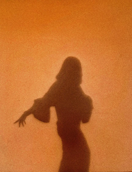 a silhouette of a woman standing in front of a wall, an album cover, inspired by Agnes Lawrence Pelton, unsplash, sand storm, 1 9 7 2, antichrist dancing at studio 54, annie lebowitz