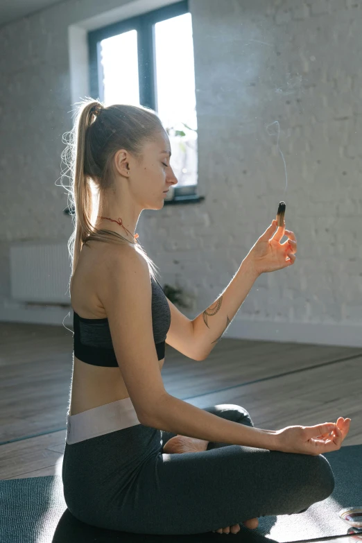 a woman sitting on a yoga mat using a cell phone, a picture, by Adam Marczyński, trending on pexels, light and space, upper body avatar, with index finger, square, oils