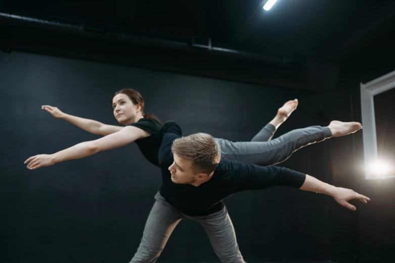 a man and woman doing a handstand in a dance studio, by Emma Andijewska, arabesque, thumbnail, schools, lachlan bailey, profile image