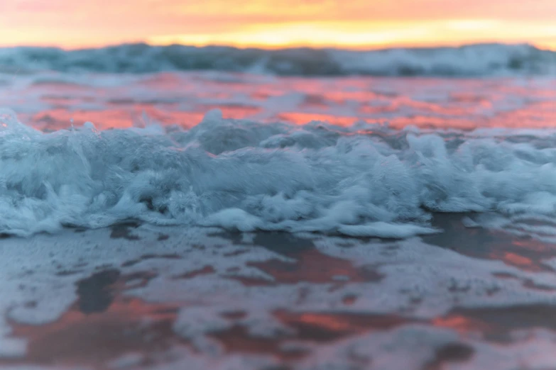 a close up of a body of water with a sunset in the background, sea foam, modeled, oceanside, unsplash 4k