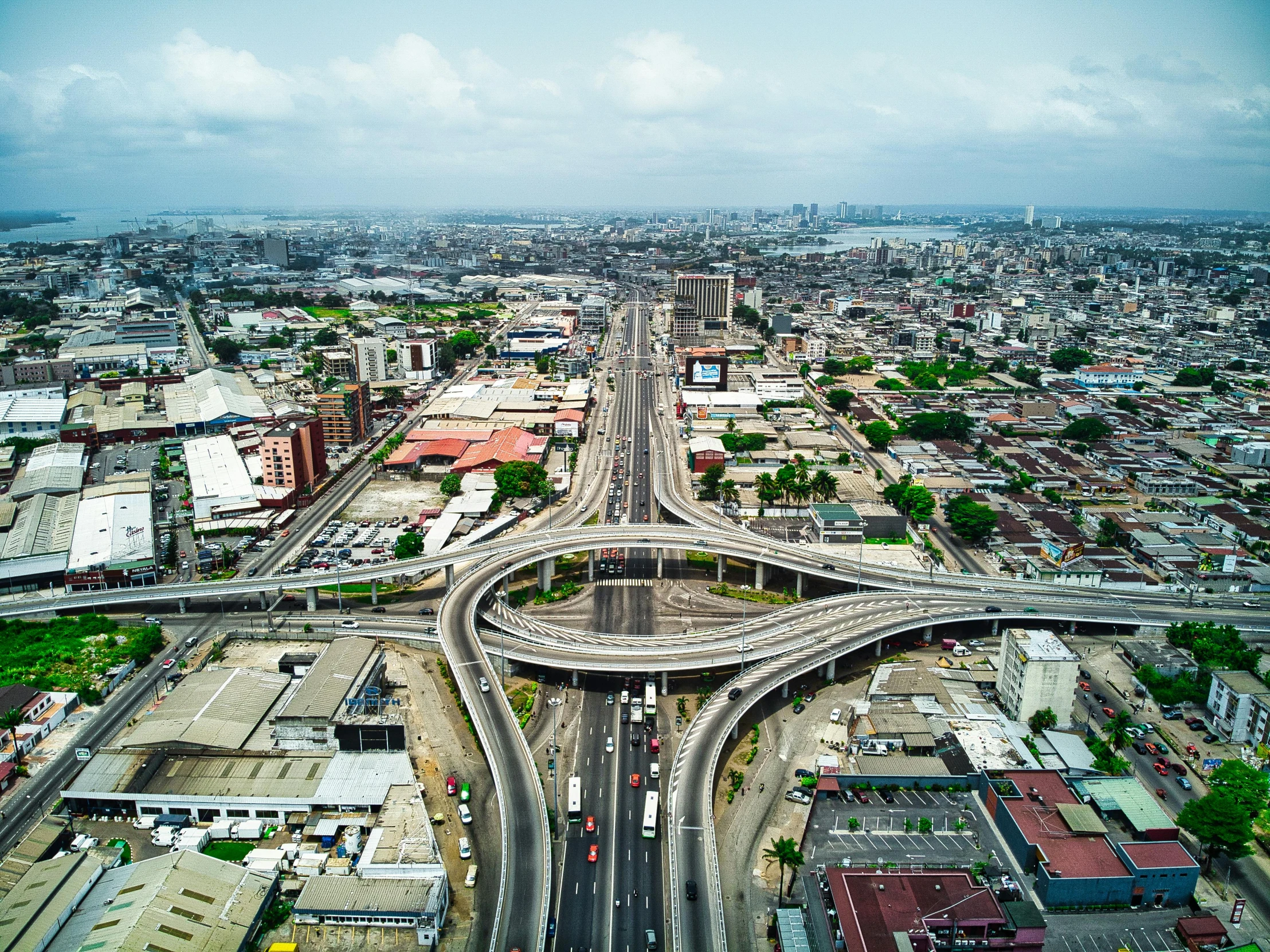 an aerial view of an intersection in a city, by Alejandro Obregón, pexels contest winner, hyperrealism, sky bridges, koyaanisqatsi, city in the background, the infrastructure of humanity