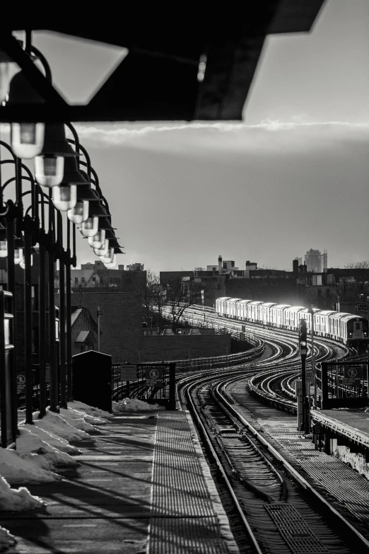 a black and white photo of a train track, a black and white photo, unsplash contest winner, harlem renaissance, city view, late afternoon, trains, curved