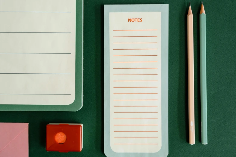 a notepad sitting on top of a desk next to a pencil, inspired by Wes Anderson, happening, green and orange theme, detail shot, various sizes, grey orange