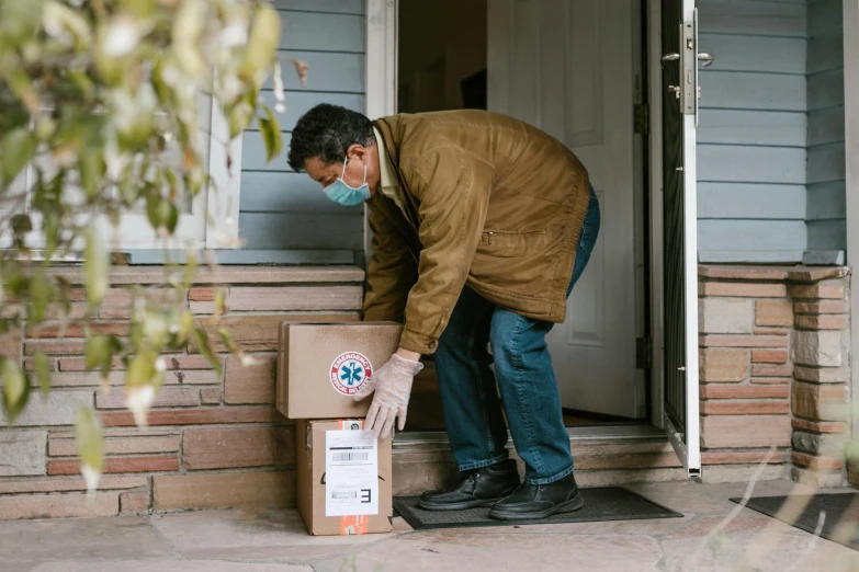 a man putting a box in front of a house, by Sam Black, pexels contest winner, medical supplies, full body, brown, postage