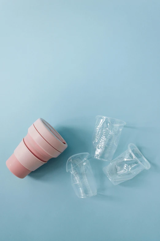 empty plastic cups on a blue background, by karlkka, light pink mist, one disassembled, silicone skin, plastic wrap