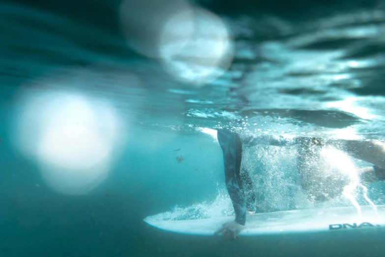 a man riding a wave on top of a surfboard, by Tom Bonson, unsplash contest winner, underwater crystals, softly lit, detailed shot legs-up, aquamarine