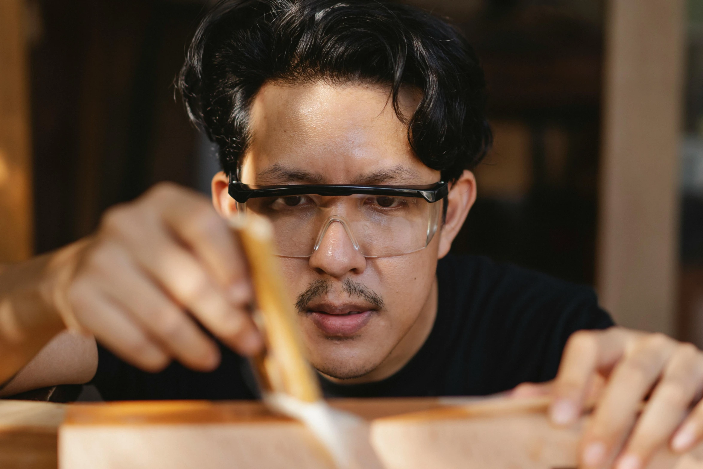 a man cutting a piece of wood with a knife, inspired by Kanō Naizen, pexels contest winner, hyperrealism, wearing black frame glasses, avatar image, rene lalique and eddie mendoza, tithi luadthong