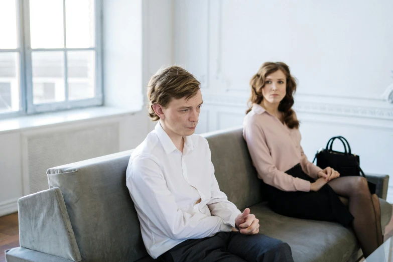 a man and a woman sitting on a couch, by Adam Marczyński, pexels, clinically depressed, on a white table, promotional image, waiting room