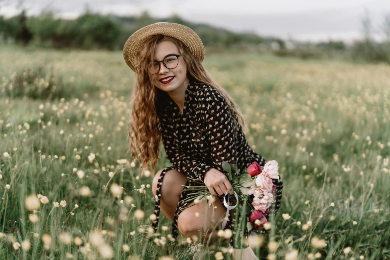 a woman kneeling in a field with flowers, pexels contest winner, square rimmed glasses, smiling fashion model, woman with hat, black