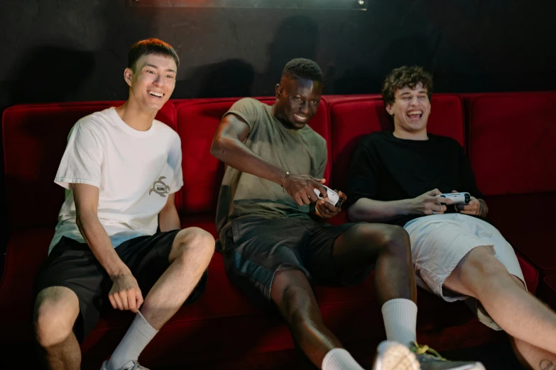 a group of young men sitting on top of a red couch, pexels contest winner, realism, gaming room, both laughing, bowater charlie and brom gerald, tall thin