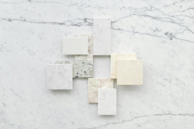 a group of white marble blocks sitting on top of a counter, inspired by Brice Marden, silver，ivory, diverse textures, vanilla, soft white rubber