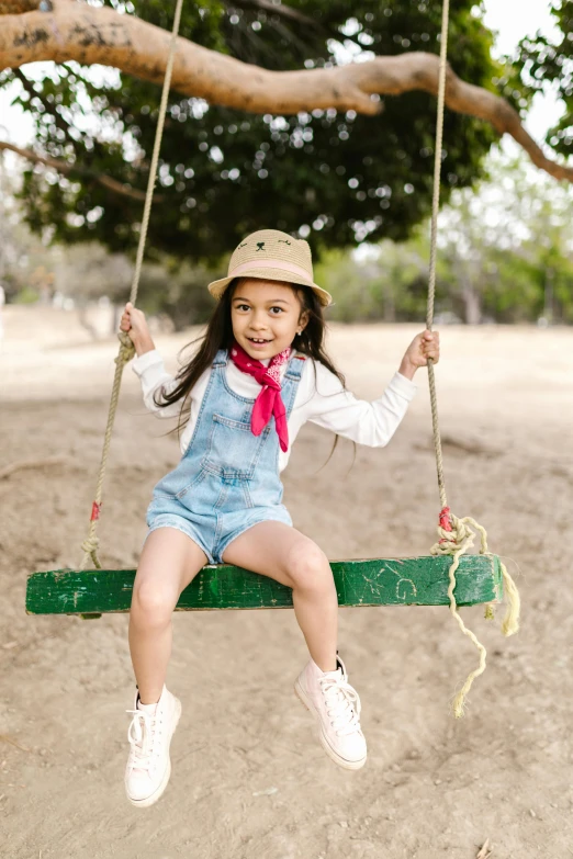 a little girl that is sitting on a swing, trending on pexels, wearing a straw hat and overalls, young asian girl, slide show, wearing denim