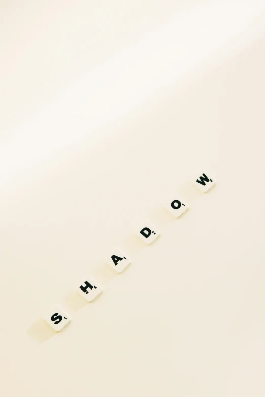 a close up of a sheet of paper with the word shadow written on it, an album cover, made of all white ceramic tiles, background image, medium shoot, album artwork