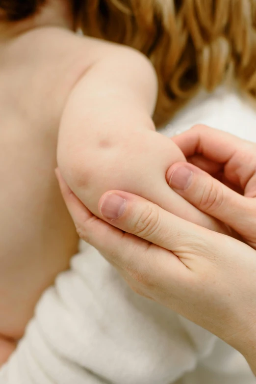 a woman holding a baby in her arms, a picture, by Gavin Hamilton, shutterstock, incoherents, partially cupping her hands, pustules, square, synthetic bio skin